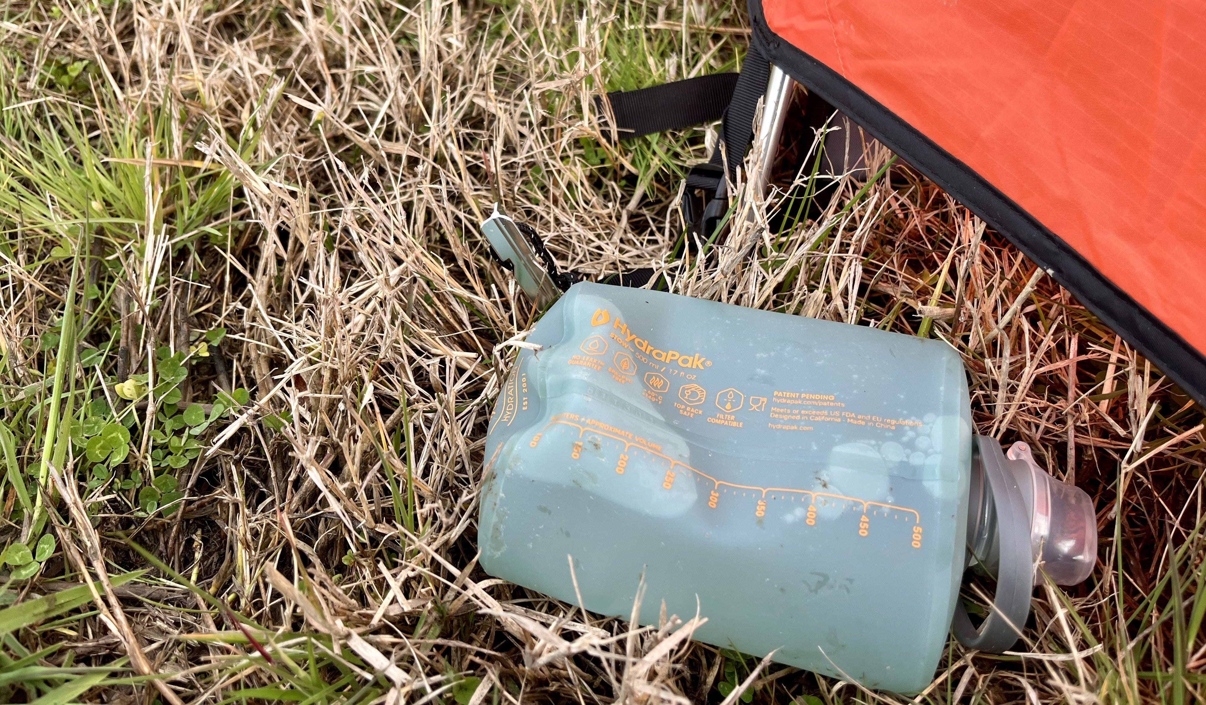 squishy Flux bottle on the grass beside a red tent